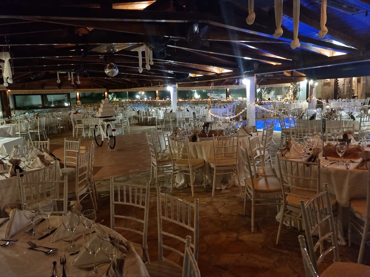 Reception hall set for wedding next to illuminated pool — Ktima Filokalis