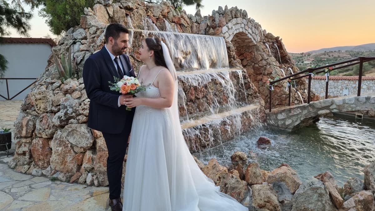 Newlywed couple by the waterfall at Ktima Filokalis wedding venue Koropi