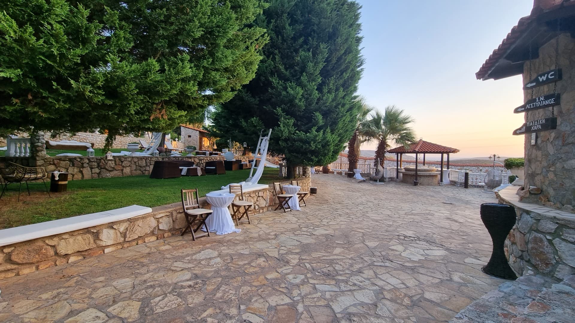 Stone courtyard with cocktail tables at Ktima Filokalis reception venue Koropi