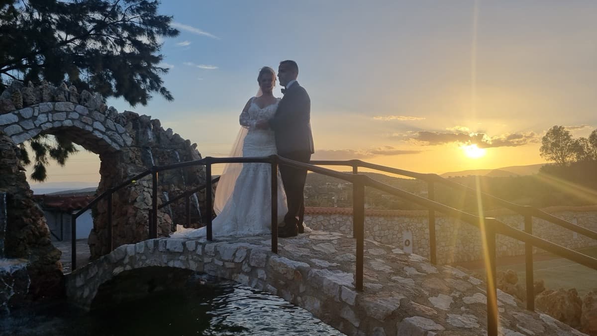 Couple on stone bridge with waterfall at sunset — Ktima Filokalis Athens